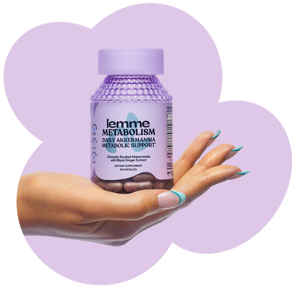 Hand holding a bottle of lemme Metabolism supplement against a purple background